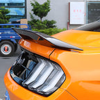 Display of Orange Ford Mustang with Carbon Fiber-Style Rear Spoiler
