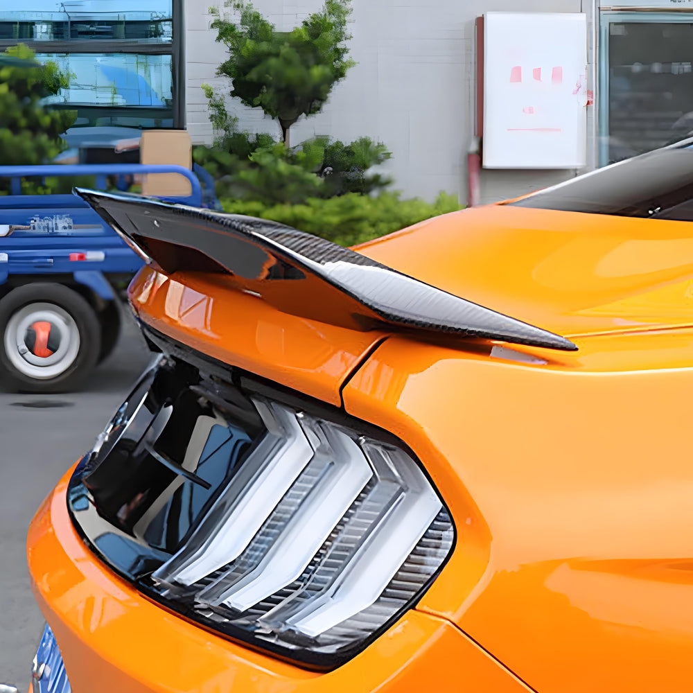 Display of Orange Ford Mustang with Carbon Fiber-Style Rear Spoiler